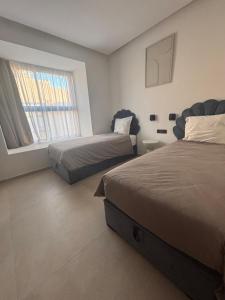 a bedroom with two beds and a window at Villa 5 suites piscine privée in Marrakesh +24 photos