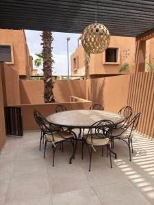 a patio with a table and chairs and a chandelier at Villa 5 suites piscine privée in Marrakesh