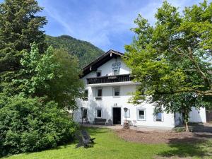 ein weißes Gebäude mit Bäumen davor in der Unterkunft Der Erberbauer in Piding