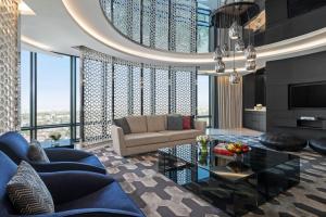 利雅德Fairmont Riyadh的客厅里有一张蓝色的沙发和一张桌子