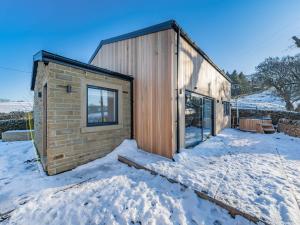 uma pequena casa de tijolos na neve na neve em Moorgate Lodge - Uk47742 em Kelbrook