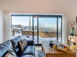 Una sala de estar con un sofá de cuero y una mesa. en Moorgate Lodge - Uk47742, en Kelbrook