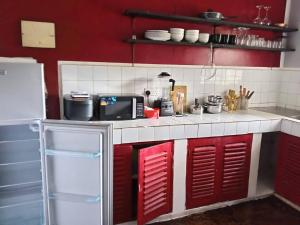 a kitchen with red and white cabinets and a microwave at Daijan villa in Ukunda