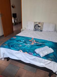 a bed with a blue and white blanket on it at Oasis do Leme in Rio de Janeiro