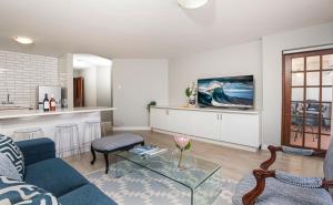 a living room with a couch and a table at A Whale of a Time Knysna in Knysna +5 photos