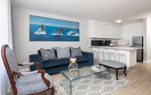 a living room with a blue couch and a kitchen at A Whale of a Time Knysna in Knysna