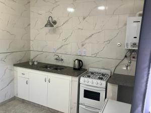 サンタフェにあるDpto planta alta microcentro Santa Feのコンロとシンクのある白いキッチン