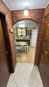 a kitchen and dining room with a brick wall at Casa Calamar I in Valeria del Mar +4 photos