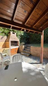 a patio with a table and chairs and a brick oven at Casa Calamar I in Valeria del Mar