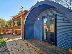 a blue shed with a door on a deck at Gallowhill Kirkside - Uk46515 in Newmill