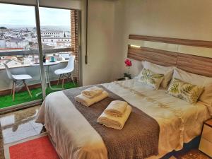 una camera da letto con un letto grande con due asciugamani sopra di Panorama Córdoba Center a Cordoba Altre 70 foto