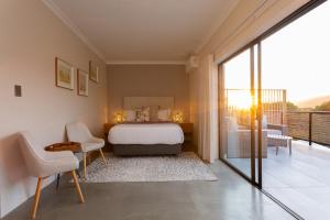 a bedroom with a bed and a balcony at IL Gattopardo in Wilderness