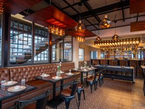 ガントクにあるMoustache Hostel Gangtokのテーブルと椅子とバーのあるレストラン