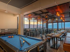 ガントクにあるMoustache Hostel Gangtokのテーブルと椅子のあるレストランのビリヤード台