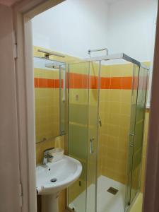 a bathroom with a sink and a glass shower at EUR Laurentina vacation home in Rome +13 photos