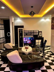 a living room with a couch and chairs and a tv at Classimo in Dakar