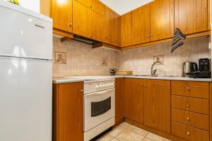 a kitchen with wooden cabinets and a white stove top oven at Panoramio Paleochora Apartments in Palaiochóra