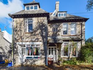 una vieja casa de piedra en la calle en Sunnycote, en Arnside