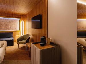 コレジアンにあるノボテル マルヌ ラ ヴァレ コレジアンのベッドと机のある寝室のある部屋