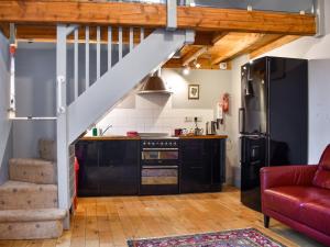 a kitchen with a staircase and a red couch at The Coach House - Uk50884 in North Walsham
