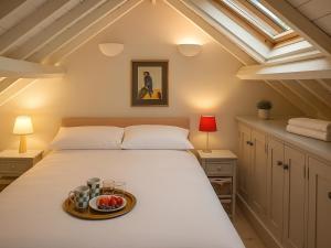 a bedroom with a bed with a tray of fruit on it at The Coach House - Uk50884 in North Walsham +10 photos