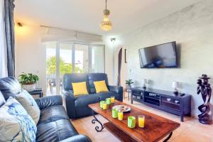 un soggiorno con un divano e un tavolo di Villa Juan by Villa Plus a Portopetro