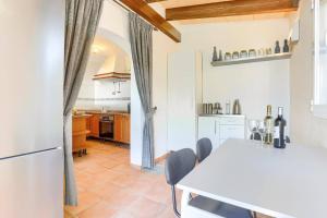 una cucina con tavolo bianco e frigorifero bianco di Villa Juan by Villa Plus a Portopetro
