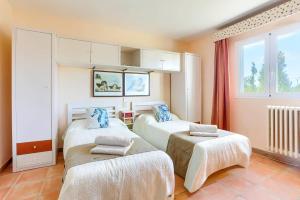 una stanza con due letti e una finestra di Villa Juan by Villa Plus a Portopetro Altre 13 foto