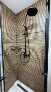 a shower in a bathroom with a wooden wall at Casa Cota in Craiova