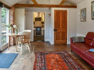 een woonkamer met een rode bank en een tafel bij The Dairy - Uk50885 in North Walsham