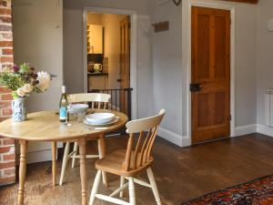 een eetkamer met een houten tafel en stoelen bij The Dairy - Uk50885 in North Walsham