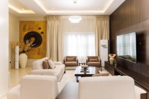 a living room with white furniture and a flat screen tv at Mozabella Apartment in Karsana