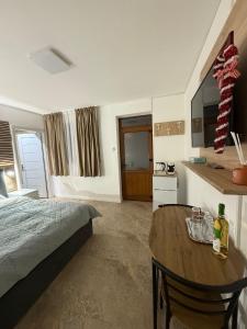 ein Schlafzimmer mit Bett und Tisch und eine Küche in der Unterkunft Casa Cota in Craiova