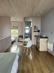 a bedroom with a bed and a table and chairs at Ventana Al Mar in Pichilemu