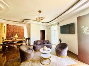 a living room with two couches and a piano at Cozy Vacation Home in Anuradhapura