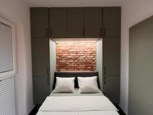 a bedroom with a bed and a brick wall at Pod Palmami in Hel