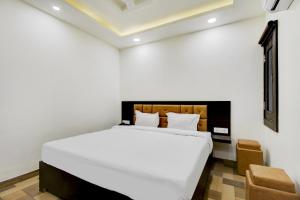 a bedroom with a large white bed in a room at Hotel O Bonsai in Bhopal