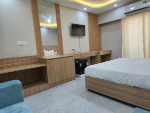 a hotel room with a bed and a television at Hotel Grand Luxury Char Dham in Vrindāvan