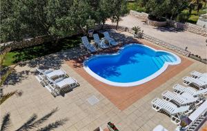 Stunning Apartment In Rab في Barbat na Rabu: اطلالة علوية على مسبح مع كراسي وطاولة بلياردو +19 صورة