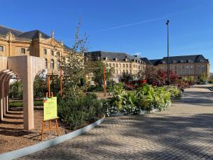 ein Gebäude mit einem Schild vor einem Garten in der Unterkunft Les Gîtes de l'ile à Metz in Metz