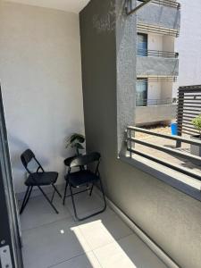 2 sedie sedute su un balcone con finestra di SkyAre Windhoek CBD a Windhoek