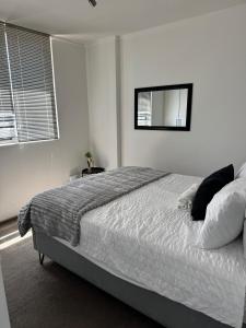 una camera da letto con un letto grande con uno specchio sul muro di SkyAre Windhoek CBD a Windhoek