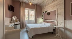 a bedroom with a bed and a table and a window at Romantic - Affitti Brevi Italia in Lecco