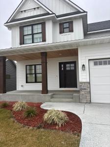 a white house with a driveway and a garage at Luxurious Sweet Escape stunning custom Home! in Rochester