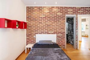 ジェノヴァにあるComfort-Moderno and Parkingのレンガの壁とベッドが備わるベッドルーム1室が備わります。