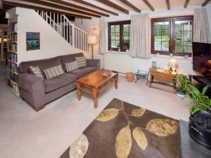 a living room with a couch and a table at 1 Stag Inn Cottages in Milburn