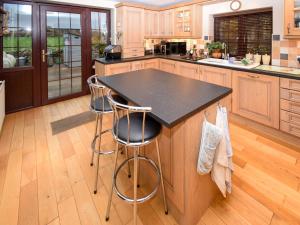 a kitchen with a island with two bar stools at 1 Stag Inn Cottages in Milburn +14 photos