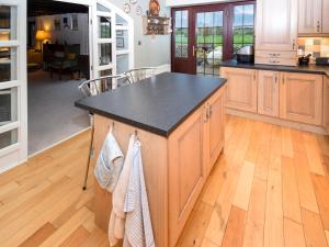 a kitchen with a island with a black counter top at 1 Stag Inn Cottages in Milburn