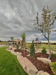 ein Garten mit Bäumen und Felsen vor einem Haus in der Unterkunft Natura-Resort Les Pletes in Palouet