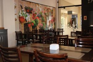 a restaurant with wooden tables and chairs and a mural at Samba Três Lagoas in Três Lagoas